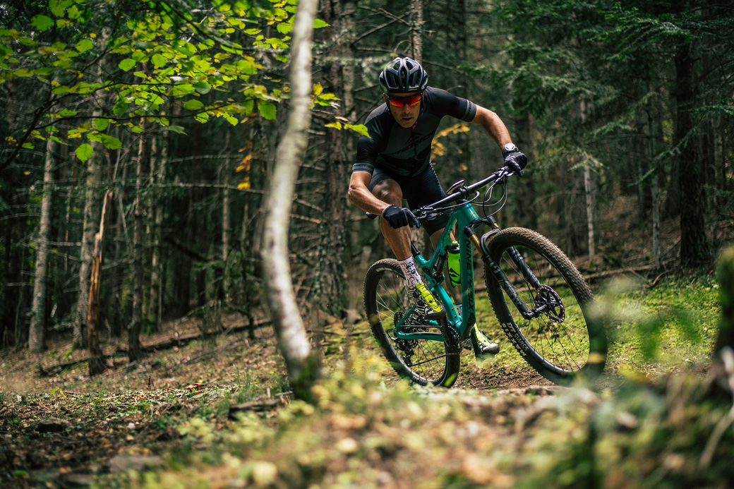 merida bikes - bike sale | guy riding a mtb bike though the forest 